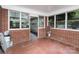 A screened porch area featuring brick walls, mosaic tile flooring, and access to a garage at 506 7Th Sw St, Hickory, NC 28602