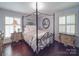 Light and airy bedroom featuring a four-poster bed, hardwood floors, shutters, and decorative mirrors at 5411 Valley Forge Rd, Charlotte, NC 28210