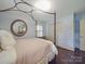 Bedroom featuring a four-poster bed, hardwood floors, a round mirror, and bright natural light at 5411 Valley Forge Rd, Charlotte, NC 28210