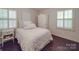 Cozy bedroom featuring neutral tones, hardwood floors, shutters, and an eye-catching decorative pillow at 5411 Valley Forge Rd, Charlotte, NC 28210