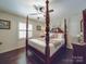Traditional bedroom featuring a four-poster bed, hardwood floors, and bright natural light at 5411 Valley Forge Rd, Charlotte, NC 28210
