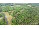 Aerial view showing a lake nearby and lush surrounding greenery with a winding drive accessing the residence at 5523 Flint Ridge Church Rd, Marshville, NC 28103