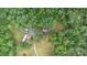 A serene aerial view of a home site nestled among lush trees, with driveway access and auxiliary buildings at 5523 Flint Ridge Church Rd, Marshville, NC 28103