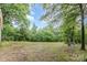 Cleared backyard space with mature trees and a swing set, perfect for outdoor activities at 5523 Flint Ridge Church Rd, Marshville, NC 28103
