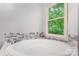 Bright bathroom featuring a soaking tub, and serene natural light from the window at 5523 Flint Ridge Church Rd, Marshville, NC 28103