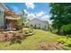 Backyard featuring a well-manicured lawn, flower beds, and patio with an umbrella at 6136 Sandy Point Ln, Belmont, NC 28012