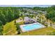 Aerial view of a community pool with a playground surrounded by lush greenery in a Gathering-friendly neighborhood at 6136 Sandy Point Ln, Belmont, NC 28012