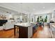 Open kitchen featuring island with sink and seating, flows into the dining and living areas with large windows at 6136 Sandy Point Ln, Belmont, NC 28012