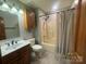 Bathroom with a single sink vanity, tub-shower combo, and wood cabinetry, providing essential functionality at 6339 River Front Dr, Harrisburg, NC 28075