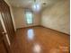 Bedroom with light hardwood floors, neutral walls, and a ceiling fan, offering a simple, relaxing space at 6339 River Front Dr, Harrisburg, NC 28075