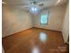 Cozy bedroom with hardwood floors, neutral walls, a ceiling fan, and a single window at 6339 River Front Dr, Harrisburg, NC 28075