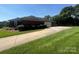 Charming single-story brick home with a well-manicured lawn and an expansive driveway at 6339 River Front Dr, Harrisburg, NC 28075