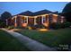 Beautiful brick home at twilight with landscaped garden, illuminated by landscape lighting at 6339 River Front Dr, Harrisburg, NC 28075