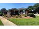 Single-story brick house boasts a beautifully maintained front yard and landscaping at 6339 River Front Dr, Harrisburg, NC 28075