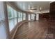 Bright sunroom with wood-look floors, brick accents, fan, and large windows offering a serene view at 6339 River Front Dr, Harrisburg, NC 28075