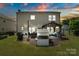 Evening view of landscaped backyard, patio with string lights, and outdoor kitchen at 7318 Rupell Dr, Charlotte, NC 28273