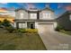 Charming two-story home featuring a well-manicured lawn, welcoming front porch, and a convenient two-car garage at 7318 Rupell Dr, Charlotte, NC 28273
