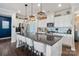 Modern kitchen with a large island, white cabinets, stainless steel appliances, and stylish pendant lighting at 7318 Rupell Dr, Charlotte, NC 28273