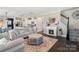 Spacious living room with a fireplace, staircase, and open layout flowing into the kitchen at 7318 Rupell Dr, Charlotte, NC 28273