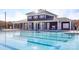 Community pool area with a modern pool house, lounge chairs, and clear blue water at 7723 Woolsey Dr, Gastonia, NC 28056