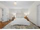 Cozy bedroom featuring a plush bed, soft lighting from bedside lamps, and warm wood flooring at 8300 Fairview Rd, Charlotte, NC 28226