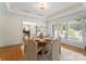 Elegant dining room with a round table set for six, large windows, and a view into the living room at 8300 Fairview Rd, Charlotte, NC 28226