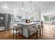 Bright, open kitchen with white cabinets, a large island, stainless steel appliances, and hardwood floors at 8300 Fairview Rd, Charlotte, NC 28226