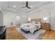 Main bedroom featuring a tray ceiling, a ceiling fan, hardwood floors, and a tufted headboard at 8300 Fairview Rd, Charlotte, NC 28226