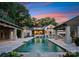 Luxury pool featuring a stone surround, cabanas, and a stunning view of the elegant home and its architecture at 8300 Fairview Rd, Charlotte, NC 28226