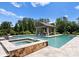 Resort-style pool and spa with stone accents, framed by lush greenery, perfect for relaxation and entertaining at 8300 Fairview Rd, Charlotte, NC 28226
