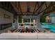 Relaxing pool cabana with a fireplace, comfortable seating, and a view of the sparkling pool and manicured greenery at 8300 Fairview Rd, Charlotte, NC 28226