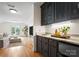 Well-appointed wet bar boasts custom cabinetry, elegant countertops, and a cozy living room in the background at 8300 Fairview Rd, Charlotte, NC 28226