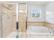 Bright bathroom with a shower, soaking tub, tile surround, neutral finishes, and a window for natural light at 865 Wingthorn Rose Dr, Gastonia, NC 28056