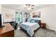 Cozy bedroom featuring a bed, a desk, and a window with curtains, offering a blend of relaxation at 865 Wingthorn Rose Dr, Gastonia, NC 28056