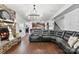 Cozy living room with a stone fireplace, modern lighting, and a large leather sectional sofa at 865 Wingthorn Rose Dr, Gastonia, NC 28056