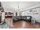 Spacious living room featuring a stone fireplace, hardwood floors, and a modern lighting fixture at 865 Wingthorn Rose Dr, Gastonia, NC 28056