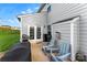 Outdoor patio with a grill, two Adirondack chairs, gray siding, and sliding glass doors at 865 Wingthorn Rose Dr, Gastonia, NC 28056