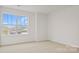 Bedroom featuring a window with scenic views and neutral walls and plush carpeting leading to other rooms in the home at 9528 Maltese Dr, Gastonia, NC 28056