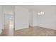 Open-concept living space with hardwood floors, white walls, modern chandelier and view to the neighborhood at 9528 Maltese Dr, Gastonia, NC 28056