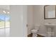 Convenient powder room featuring a pedestal sink, toilet and modern mirror at 9528 Maltese Dr, Gastonia, NC 28056