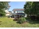 Home exterior featuring a well-maintained lawn, covered patio, and mature trees for a private outdoor space at 10217 Falling Leaf Dr, Concord, NC 28027