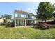 Expansive backyard featuring a covered patio, lush lawn, and mature trees for outdoor enjoyment at 10217 Falling Leaf Dr, Concord, NC 28027