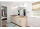 Bright bathroom with double vanity, large mirror, neutral walls, and tile floor at 10217 Falling Leaf Dr, Concord, NC 28027