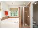 Well-lit bathroom with a tub, shower, and window view, combining comfort with natural light at 10217 Falling Leaf Dr, Concord, NC 28027