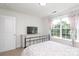 Well-lit bedroom with carpet, dresser, and large window with patterned curtains at 10217 Falling Leaf Dr, Concord, NC 28027