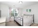 Cozy bedroom features a black metal bed frame and a large window overlooking the front yard at 10217 Falling Leaf Dr, Concord, NC 28027