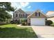 Charming two-story brick home with a well-manicured lawn and a two-car garage at 10217 Falling Leaf Dr, Concord, NC 28027