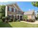 Inviting two-story home with brick facade, manicured lawn, and a welcoming front entrance at 10217 Falling Leaf Dr, Concord, NC 28027