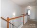 Upstairs hallway with carpet, white banister, and light fixture, providing access to other rooms at 10217 Falling Leaf Dr, Concord, NC 28027