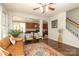 Living room with hardwood floors, stairs, access to the kitchen and view of the backyard at 10217 Falling Leaf Dr, Concord, NC 28027